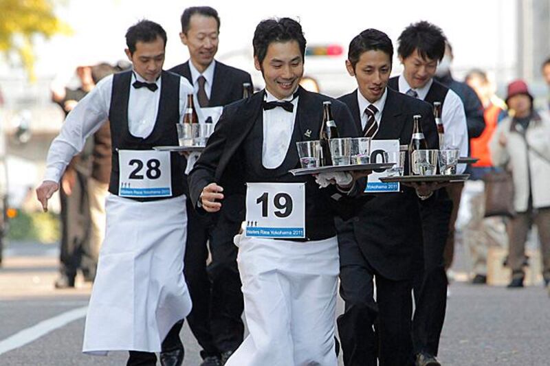 Waiters carry trays of drinks as they take part in a race through the streets during waiters' race in Yokohama, near Tokyo, Wednesday, Nov. 23, 2011. (AP Photo/Itsuo Inouye)