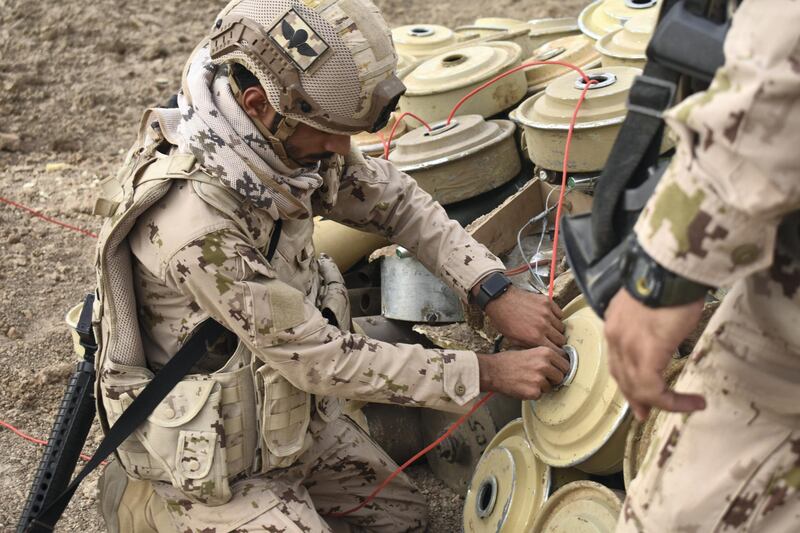 An Emirati soldier threads detonator cord through a captured Houthi landmine. Soldiers told The National they are carrying out the controlled explosion of hundreds of  landmines every few days. Gareth Browne / The National