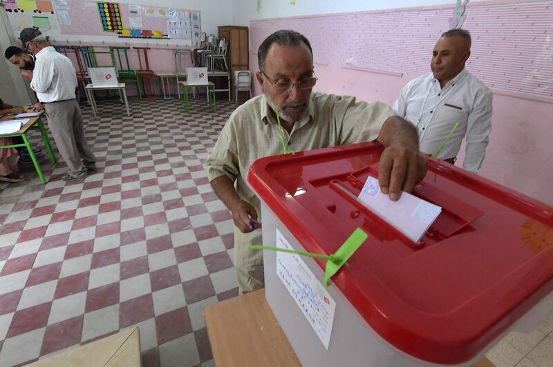 Tunisians go to the polls on Monday to vote on a draft constitution proposed by President Kais Saied. Here, a vote is cast at a polling station in the capital, Tunis. AFP