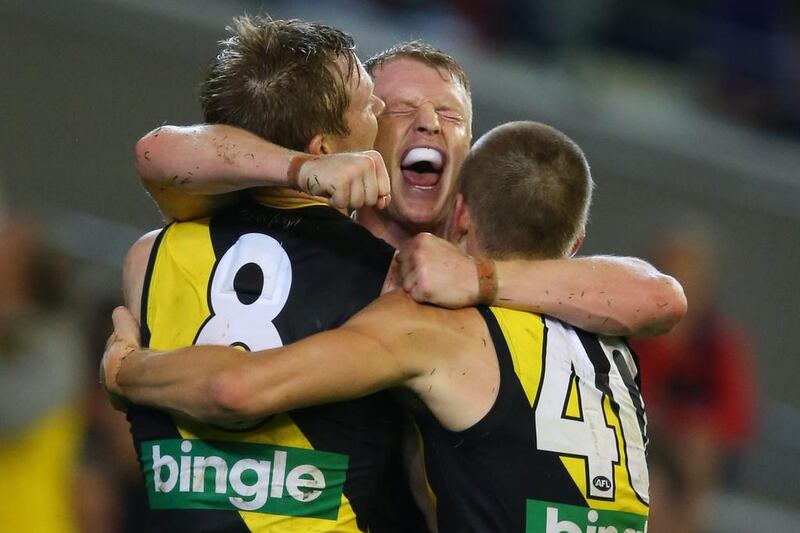 AFL player Josh Caddy of the Richmond Tigers, centre, celebrates his winning goal against and the Melbourne Demons at Melbourne Cricket Ground. Michael Dodge / AFL Media / Getty Images