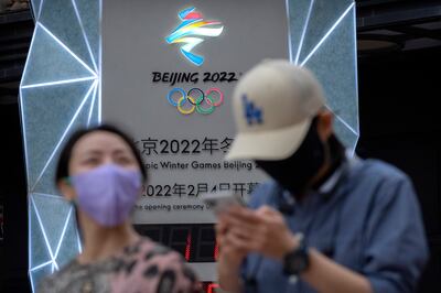 People walk past a countdown clock to the Beijing 2022 Winter Olympics in Beijing. AP 