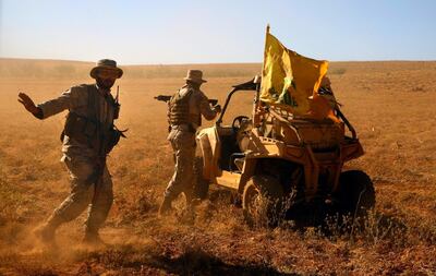 FILE - This July 29, 2017 file photo, Hezbollah fighters stand near a four-wheel motorcycle positioned at the site where clashes erupted between Hezbollah and al-Qaida-linked fighters in Wadi al-Kheil or al-Kheil Valley on the Lebanon-Syria border. The British government will make inciting support for Hezbollah a criminal offense as senior officials accused the Iran-backed organization of destabilizing the Middle East. (AP Photo/Bilal Hussein, File)