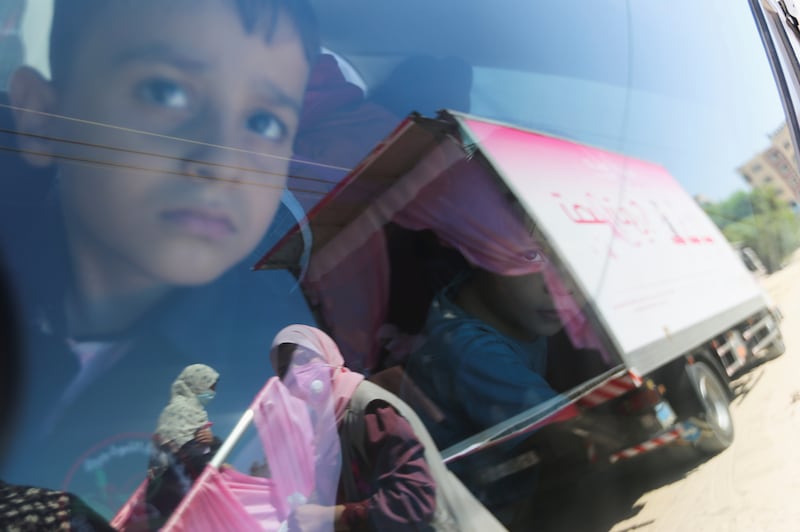 Waiting in the car, a boy watches as women go to be tested.