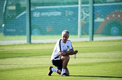 France's head coach Didier Deschamps kneels on the pitch during a training session in Istra, west of Moscow on June 27, 2018, during the Russia 2018 World Cup football tournament. / AFP / FRANCK FIFE
