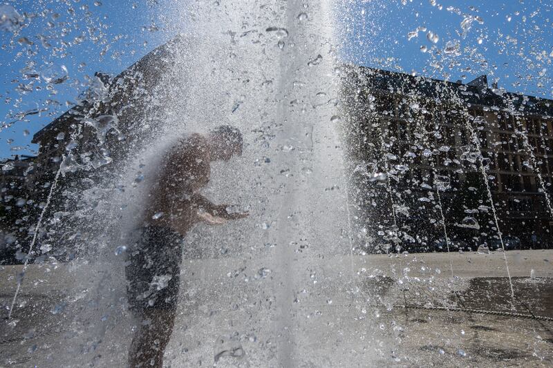 A man cools off in the city centre of Frankfurt, Germany, as temperatures reached up to 40°C