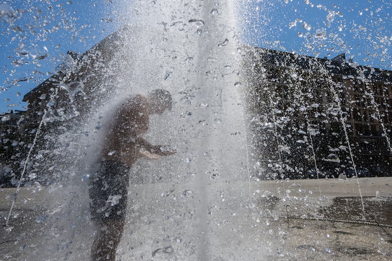 A man cools off in the city centre of Frankfurt, Germany, as temperatures reached up to 40°C