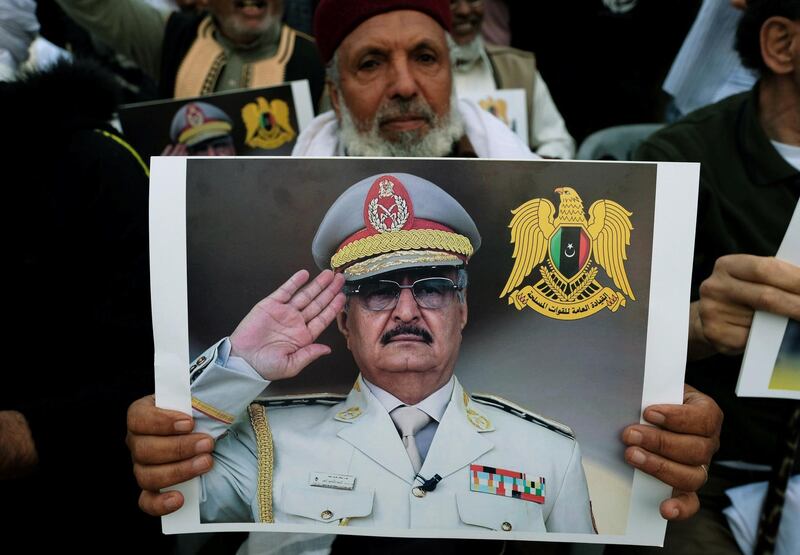FILE PHOTO: A Libyan man carries a picture of Khalifa Haftar during a demonstration to support Libyan National Army offensive against Tripoli, in Benghazi, Libya April 12, 2019. REUTERS/Esam Omran Al-Fetori/File Photo
