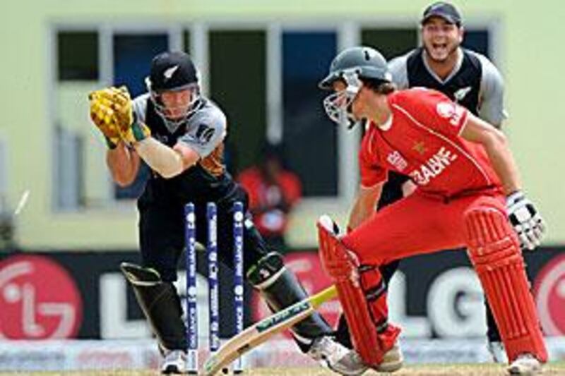 New Zealand's Gareth Hopkins, left, stumps Craig Ervine of Zimbabwe for one at Providence Stadium. The Kiwis won by nine wickets on D/L method in the rain-curtailed match.