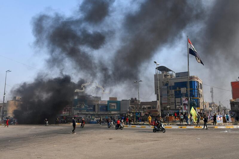 Iraqi protesters are pictured next to burning tyres during clashes with police during anti-government demonstrations in the city of Nasiriyah in the Dhi Qar province in southern Iraq.  AFP