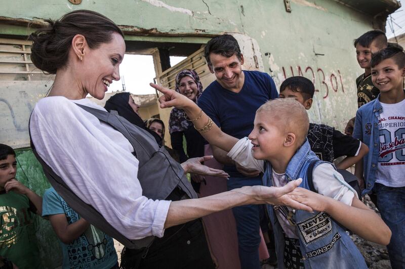 MOSUL, IRAQ - JUNE 16: (EDITORIAL USE ONLY) In this handout image provided by United Nations High Commission for Refugees, UNHCR Special Envoy Angelina Jolie meets Falak, 8, during a visit to West Mosul during a visit to Iraq, on June 16, 2018. Falak has a gene disorder and PTSD, she spoke to Jolie about seeing a man killed in front of her during the ISIS occupation of the city. Less than a year after its liberation, much of West Mosul still lies in ruins. (Photo by Andrew McConnell / UNHCR via Getty Images)