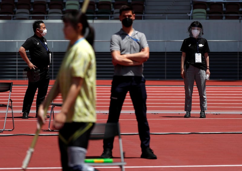 Officials wearing protective face masks are seen in the women's pole vault final at the morning session of the athletics test event. Reuters