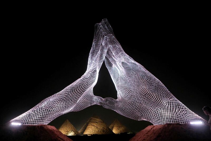 An installation by Italian artist Lorenzo Quinn faces the Giza Pyramids on October 23. The artwork was part of the first international exhibition to take place at the site. AFP