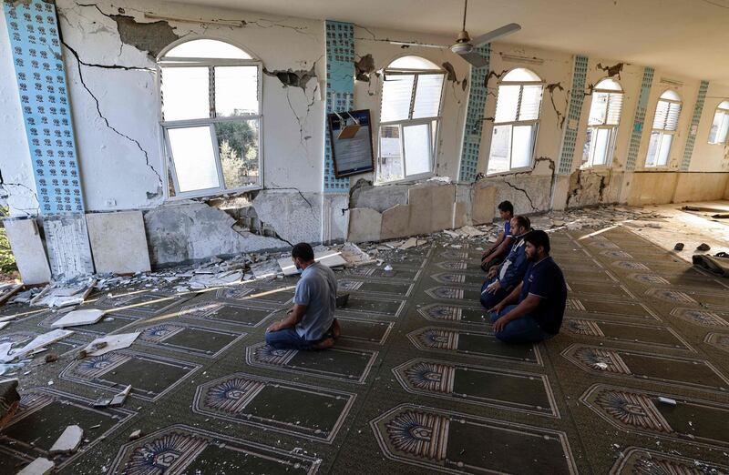 Palestinians pray at a mosque heavily damaged during the May 2021 conflict between Hamas and Israel. AFP