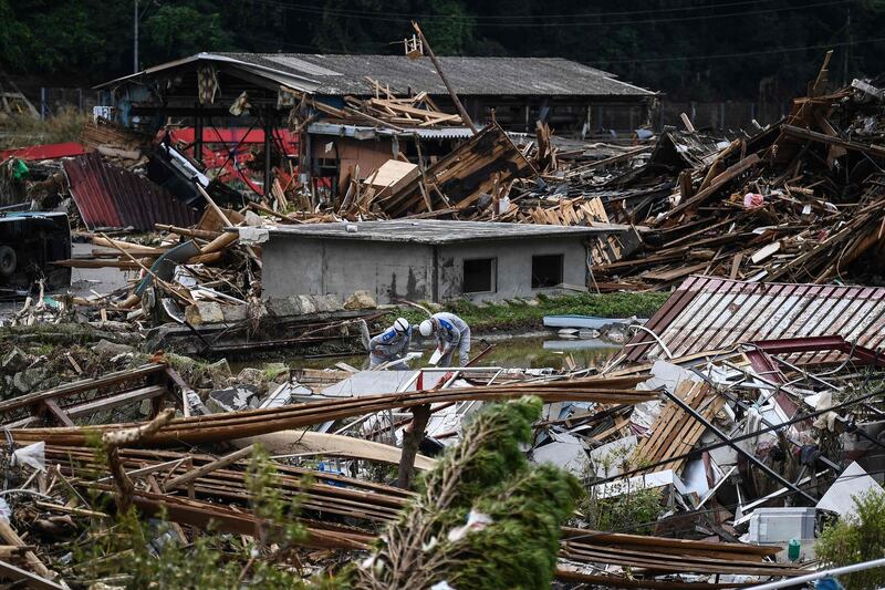 Workers survey the devastation following days of heavy rain and flooding in the village of Kuma, Kumamoto prefecture, Japan. AFP