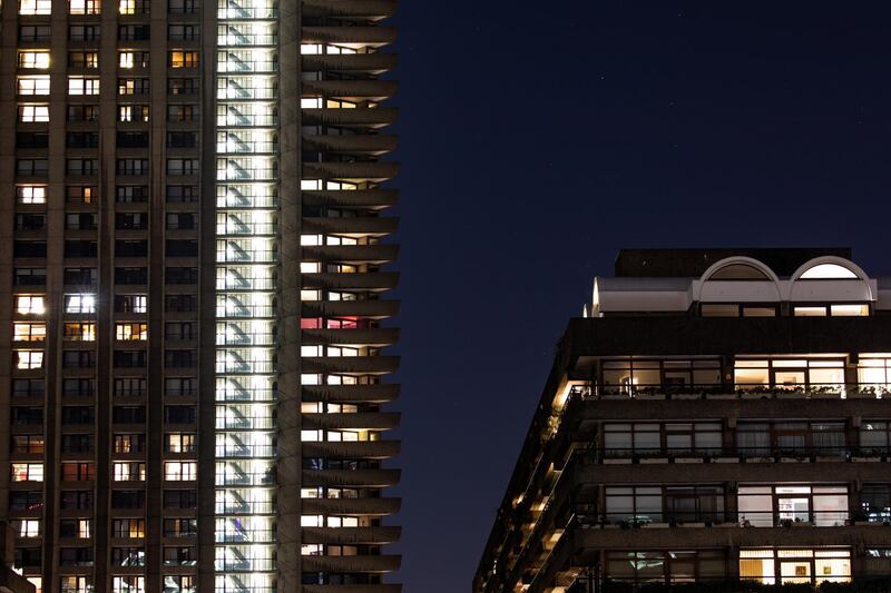 Lights are seen inside residential properties in the Barbican Estate in London, England. Getty Images