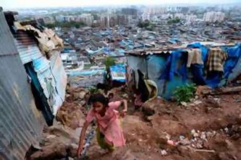 An Indian child climbs a steep bank of soil to reach her house in a slum of Mumbai on June 19, 2008. Millions have flocked to urban centres for work, contributing to the current housing shortage of 25 million homes across Indian cities. Housing concerns are particularly acute in India's financial capital where office and residential prices are amongst the highest in the world and nearly eight million of the 17 million people scramble for this. Nearly 55 percent of Mumbai's population live in the slums. Slums have been multiplying 70 percent in the decade since 1991, when India introduced market reforms. Nearly two years ago, India's Supreme Court approved a retail and office plan for a sprawling set of abandoned textile mills in Mumbai, which triggered construction of shopping malls, cinemas and office space on the 600-acre site bringing rich returns to developers in the peninsula city on the Arabian Sea. AFP PHOTO/ Pal PILLAI