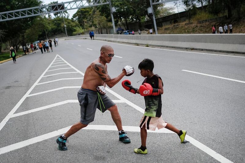 A young boxer trains outdoors with his coach on Boyaca Avenue in Caracas, Venezuela, amid the coronavirus pandemic. AP