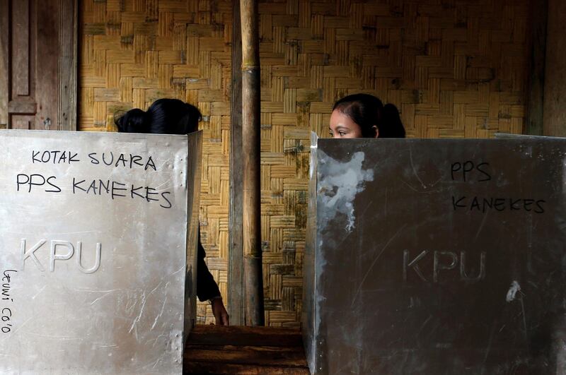 Baduy women talk behind ballot boxes while casting their vote during regional elections at Kanekes village in Rangkasbitung, Banten province, Indonesia, on June 27, 2018. Beawiharta / Reuters