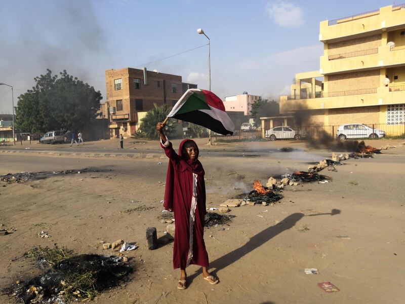 A Sudanese protester waves a national flag during a rally in the capital Khartoum to condemn the "massacre" of five demonstrators including four high school students at a rally in a central town of Al-Obeida. AFP