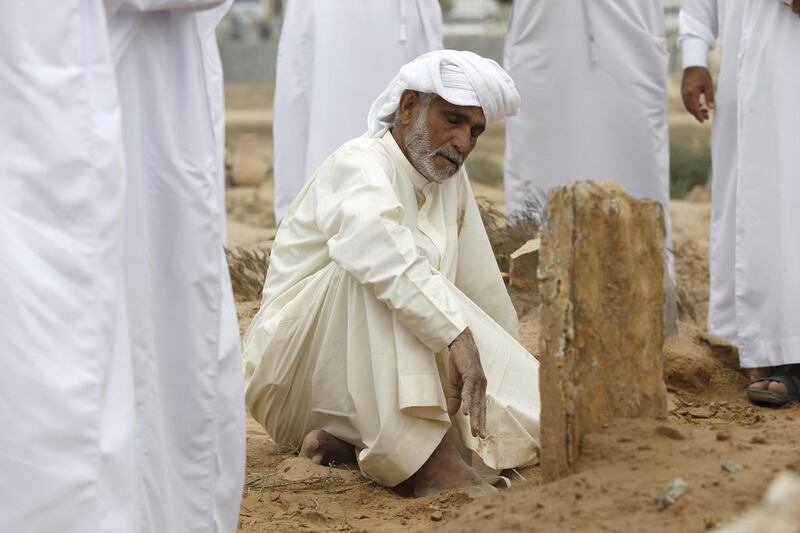 Ali Abdullah Al Qaidi, the uncle of Emirati police officer Tariq Al Shehi who was killed by an improvised bomb in Bahrain while being deployed as part of a joint Arabian Gulf force, sits next to his nephew’s grave. Antonie Robertson / The National