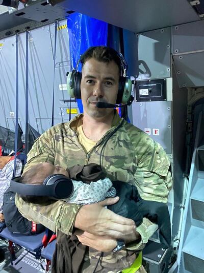 Sgt Andy Livingstone held the baby girl while her exhausted mother grabbed some rest on the flight from Kabul to an airbase in the UAE. Photo: RAF