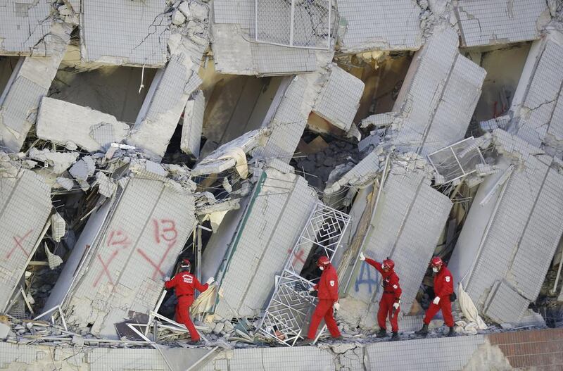 Emergency rescuers continue to search for missing people in a building that collapsed after an earthquake in Tainan. Rescuers on Sunday found signs of life within the remains of the high-rise residential building that collapsed in a powerful, shallow earthquake in southern Taiwan. Wally Santana / AP