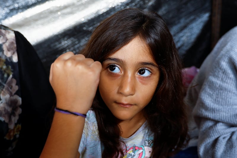 Palestinian Ali Daba and his wife have separated their children and given them bracelets to help identify them in case they are killed in Israeli strikes. Their daughter shows her bracelet at their shelter in Khan Younis. Reuters