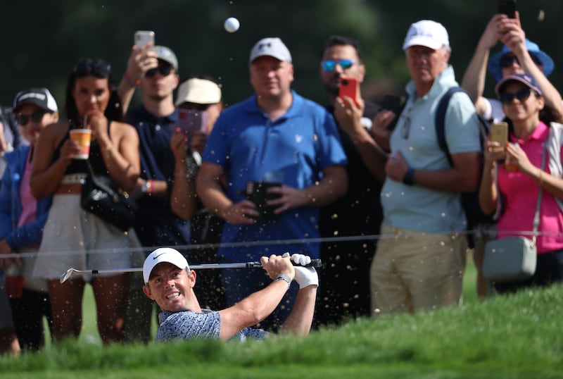 Rory McIlroy plays a shot from a greenside bunker on the 14th hole. Getty