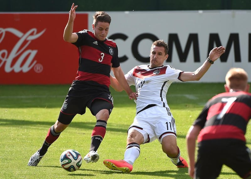 Germany's Miroslav Klose, right, makes a tackle on Germany U-20 midfielder Thomas Pledl during a practice match between the sides on Sunday as the Germans prepare for the 2014 World Cup. Patrik Stollarz / AFP / May 25, 2014