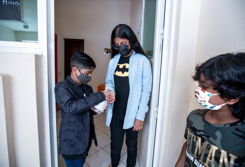 Ayaan Tariq, 7, sanitizes his friends hands, Ayesha, 10, before lending her books from his library on June 22, 2021.  Victor Besa / The National.
Reporter: Anam Rizi for News