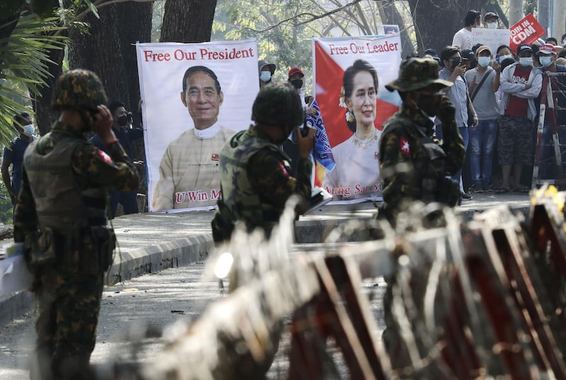 Soldiers stand guard in front of banners calling for the release of Myanmar State Counselor Aung San Suu Kyi and President Win Myint during a protest outside the Central Bank in Yangon, Myanmar. EPA