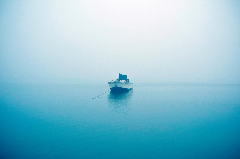 UMM AL QUWAIN, UNITED ARAB EMIRATES, MARCH 10, 2014. A fishing boat moored off the coast at the Umm Al Quwain fish souq sits suspended in the morning fog.  (Photo: Antonie Robertson/The National) Journalist: Jen Bell. Section: Northern Coverage/Arts & Life. POSSIBLE FOCAL POINT ANNIVERSARY EDITION  *** Local Caption *** AR_1003_Umm_Al_Quwain_Fish-02.jpg