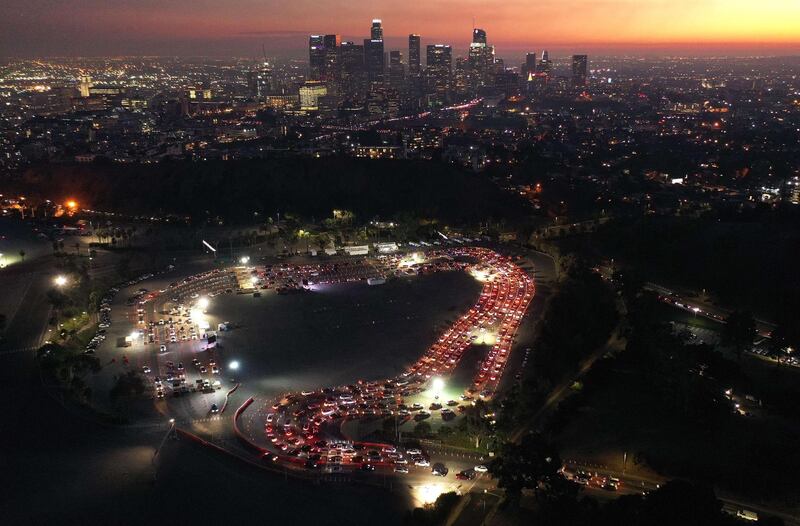 Cars are lined up at Dodger Stadium for Covid-19 testing as dusk falls over downtown in Los Angeles, California. AFP