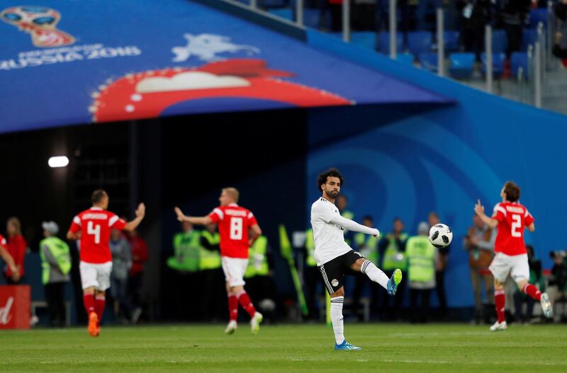 Mohamed Salah looks dejected as Russia players celebrate their first goal. Lee Smith / Reuters