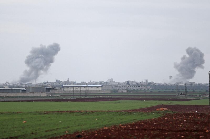A picture taken from the town of Sarmin in northwestern Syria on February 21, 2020 shows smoke billowing over the village of Qaminas, about 6 kilometres southeast of Idlib city, following reported Syrian air strikes.   / AFP / Omar HAJ KADOUR
