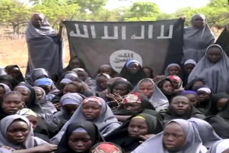 A screengrab taken on May 12, 2014, from a video released by Nigerian Islamist extremist group Boko Haram obtained by AFP shows girls wearing the full-length hijab holding a flag reading "There is no god, but Allah" and "Mohammed is Allah's prophet" at an undisclosed rural location. Boko Haram released a new video on claiming to show the missing Nigerian schoolgirls, alleging they had converted to Islam and would not be released until all militant prisoners were freed.  A total of 276 girls were abducted on April 14 from the northeastern town of Chibok, in Borno state, which has a sizeable Christian community. Some 223 are still missing. AFP PHOTO / BOKO HARAM 
RESTRICTED TO EDITORIAL USE - MANDATORY CREDIT "AFP PHOTO / BOKO HARAM" - NO MARKETING NO ADVERTISING CAMPAIGNS - DISTRIBUTED AS A SERVICE TO CLIENTS (Photo by HO / BOKO HARAM / AFP)