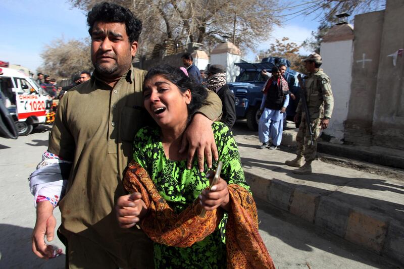 A man and a woman react as they run out after gunmen attacked the Bethel Memorial Methodist Church in Quetta, Pakistan. Naseer Ahmed / Reuters