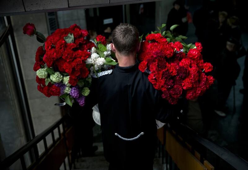 A funeral steward carries flowers laid by the coffin of regional parliament member Vyacheslav Markin, in Odessa, Ukraine. Markin, who was known for speaking out against the government in Kiev, was buried on Monday while about 300 pro-Russian supporters shouted ‘Hero, hero!’ Markin died Sunday from burn wounds sustained in Friday’s fire. Vadim Ghirda / AP Photo