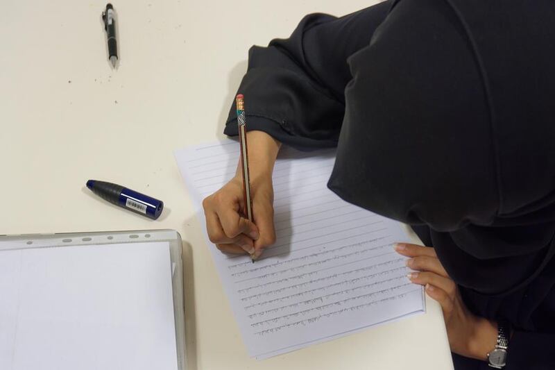 Students at Zayed University write in their native Arabic for a story on preserving the Emirati dialect. Delores Johnson / The National 