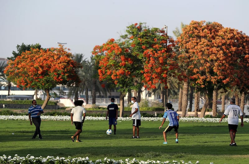 DUBAI, UNITED ARAB EMIRATES , May 27 – 2020 :- People wearing protective face mask as a preventive measure against the spread of coronavirus and playing football in the green area outside the closed Zabeel park in Dubai. (Pawan Singh / The National) For News/Online/Stock/Instagram