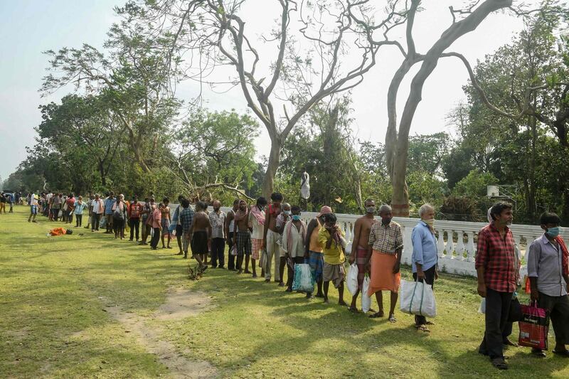 Migrant labourers queue to collect food distributed by locals at a roadside last month in Kolkata. Dibyangshu Sarkar / AFP