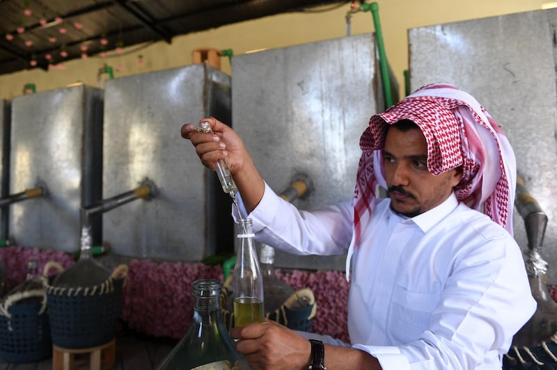 Salman fills a bottle with distilled Taif rose oil. AFP
