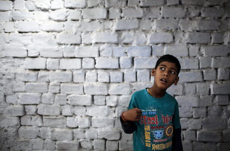 Eight-year-old Abhi, who suffers from mental and physical disabilities, plays outside his house at a slum in Bhopal.