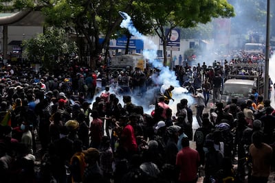 Protesters throw back tear gas canisters as they rally outside Prime Minister Ranil Wickremesinghe's office in Colombo on Wednesday. AP