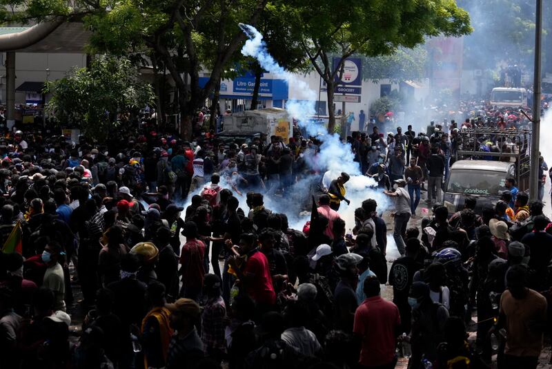 Protesters throw teargas shells. AP Photo