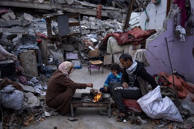 Members of the Al-Rabaya family break their fast outside their home destroyed by Israeli airstrikes in Rafah, Gaza Strip. AP