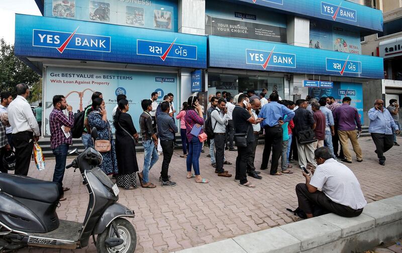 FILE PHOTO: People wait outside a Yes Bank branch to withdraw their money in Ahmedabad, India, March 6, 2020. REUTERS/Amit Dave/File Photo