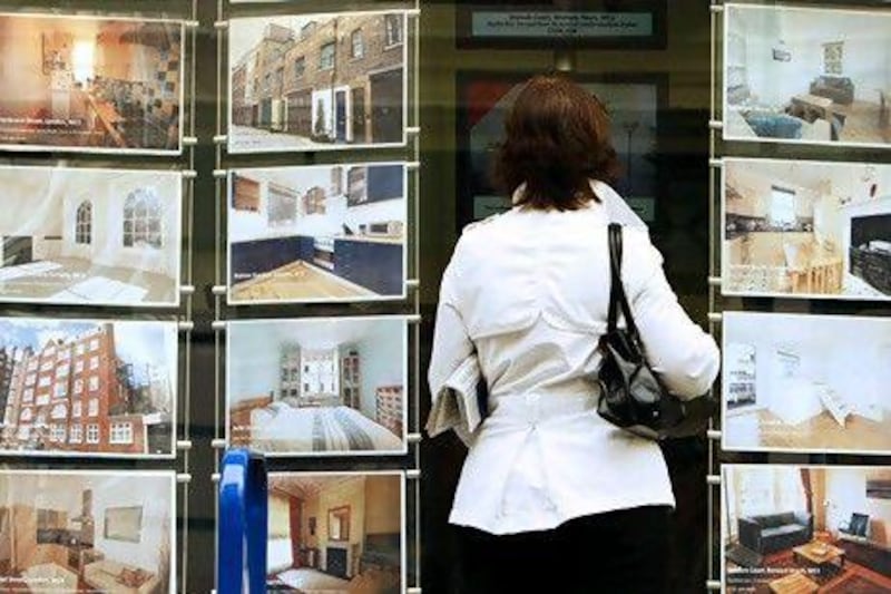 A woman looks at properties for sale in the window of an estate agent in central London. Reuters