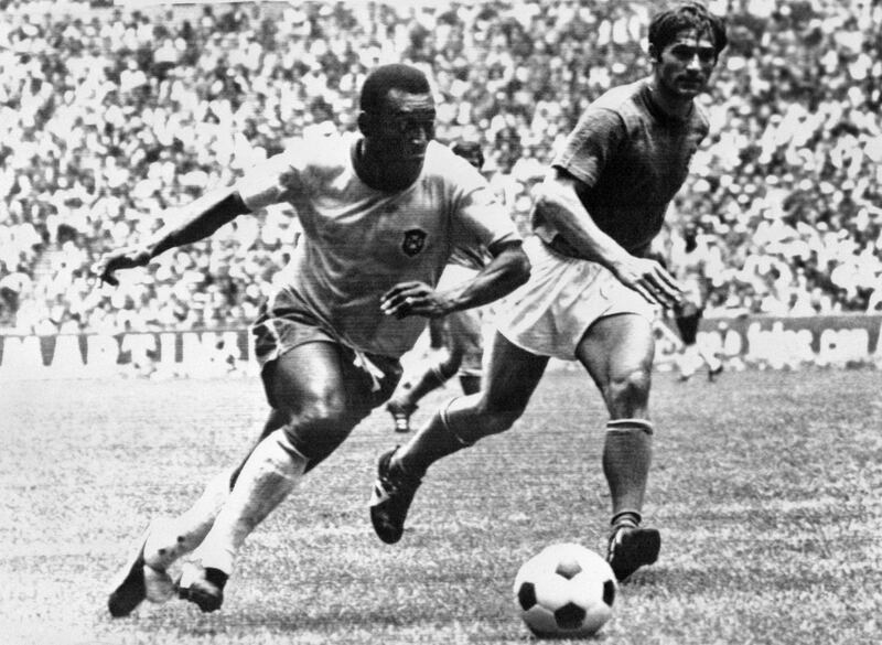 (FILES) In this file photo taken on June 21, 1970 Brazilian midfielder Pelé (L) dribbles past Italian defender Tarcisio Burgnich during the World Cup final in Mexico City. - Fifty years ago this month, modern football was born in Mexico, kicking, yelling and live in vibrant colour for a global audience. 
This weekend marks the anniversary of the quarterfinals as a star-studded cast played an increasingly thrilling series of knockout games which built to a dazzling final as the first colour World Cup ended with an unparalleled display by a technicolour team. (Photo by STAFF / AFP)
