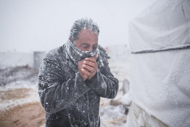 Lebanon / Syrian Refugees / A Syrian man tries to warm himself as snow falls in the Terbol tented settlement in the Bekaa Valley, on 11 December 2013. The Alexa storm has brought severe weather to Lebanon and much of the Middle East, affecting tens of thousands of Syrian refugees. / UNHCR / A. McConnell / December 2013